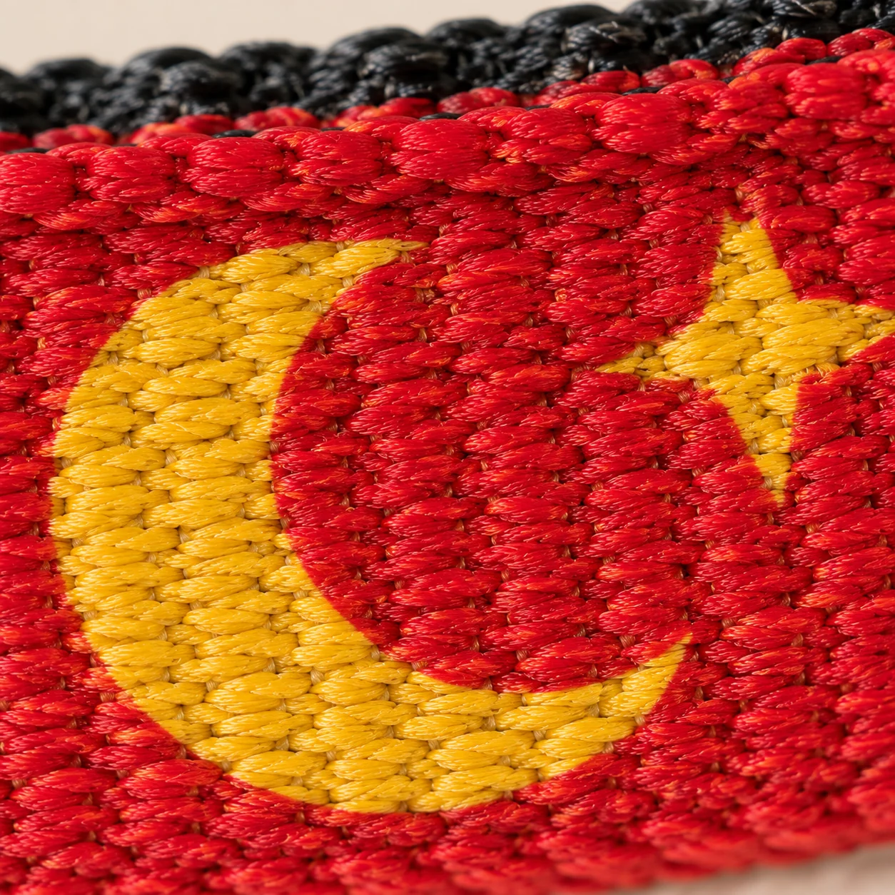 macro du tissage de la sangle, le motif imprimé ressortant sur le fond coloré