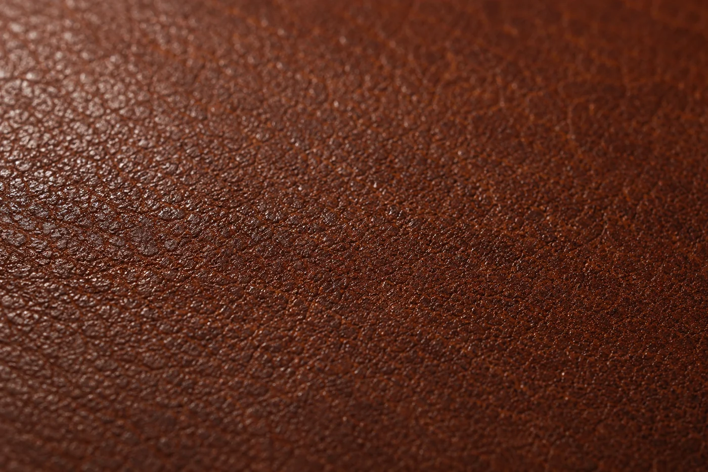 macro du grain du cuir brun, pores et variations naturelles de la peau