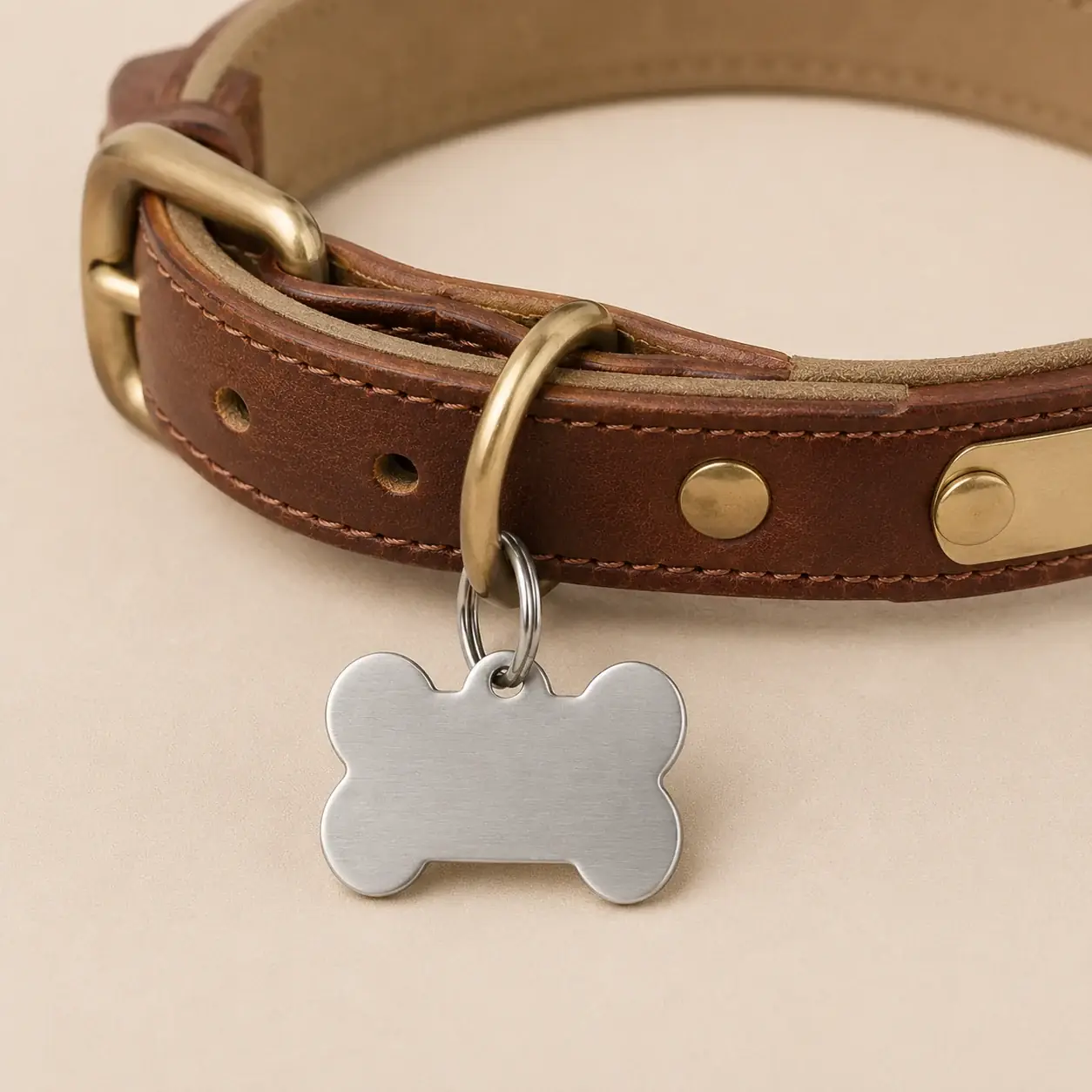 médaille os suspendue à l’anneau d’un collier en cuir brun à boucle laiton